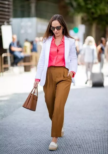 With hot pink button down shirt, white long blazer, sunglasses, brown loose trousers and brown leather bag