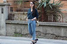 With navy blue button down shirt, loose jeans, beige and black bag and black leather sandals