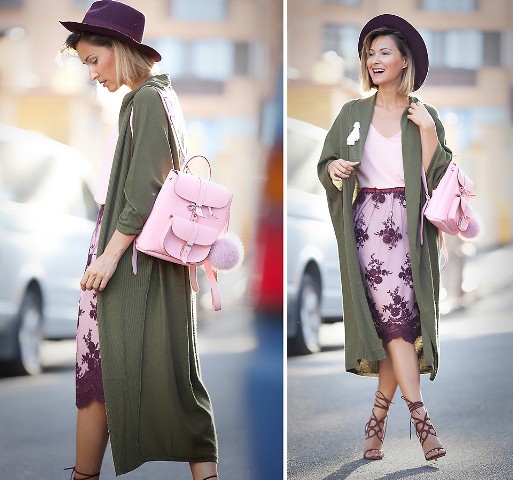 With pale pink top, olive green midi trench coat, lilac and purple lace knee length skirt, purple wide brim hat and purple lace up high heel sandals