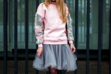 With pink and gray floral printed sweatshirt, gray skirt, black tights and black lace up ankle boots