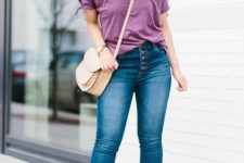 With purple loose t-shirt, beige crossbody bag, cuffed skinny jeans and light brown cutout ankle boots