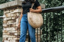With straw hat, rounded sunglasses, black t-shirt, classic jeans and beige straw round bag