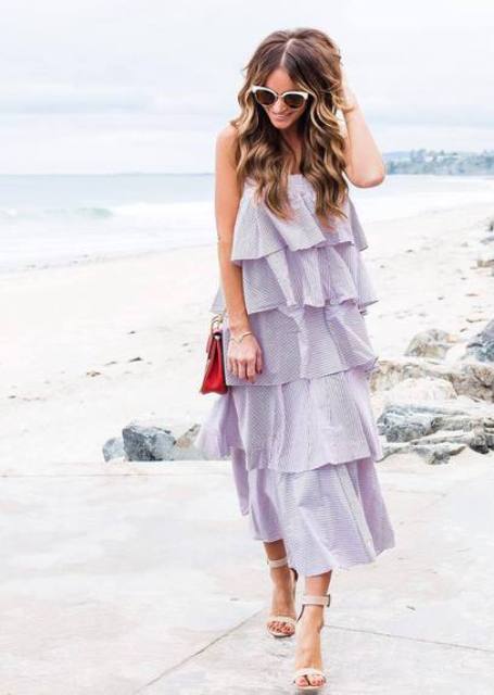 With white framed sunglasses, red chain strap bag and lilac ruffled tiered sleeveless midi dress