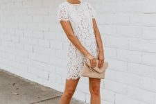 With white lace short sleeved mini dress and beige leather clutch