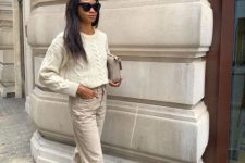 With white loose sweater, sunglasses, light gray leather bag and beige lace up ankle boots