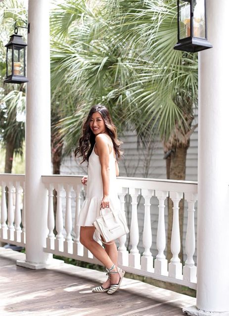 With white sleeveless mini dress and white leather tote bag