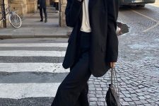 a black pantsuit with an oversized blazer, a white t-shirt, a chain necklace, white trainers and a black bag