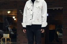 a bold and contrasting look with a black turtleneck, leather pants and combat boots, a white denim jacket
