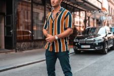 a bright vertical stripe short-sleeved shirt, teal joggers, white sneakers and a white watch are great for spring or summer