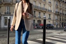 a brown t-shirt, a beige blazer, blue cropped jeans, tan boots and a brown bag for a Parisian chic outfit