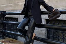 a chic party look in total black, with a one shoulder top, leather pants, leather sliders, an oversized blazer and a woven clutch