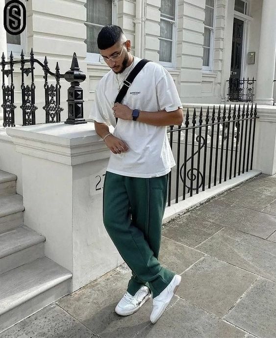 a comfortable outfit wiht an oversized white t-shirt, green sweatpants, white trainers and a black crossbody bag