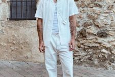 a layered summer look with a white tank top, a white linen button down, white jeans, black slippers, a black hat