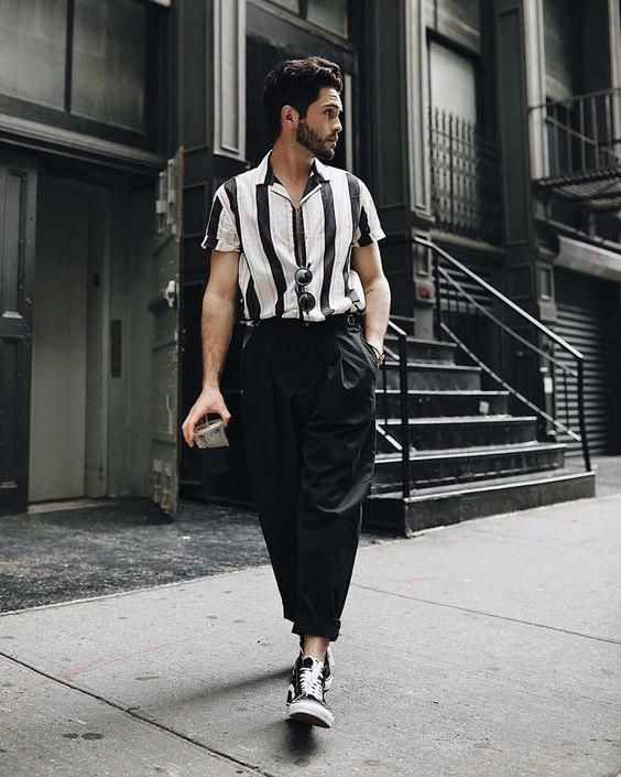 a monochromatic outfit with a vertical stripe short-sleeved shirt, black cropped pants, black sneakers and sunglasses is cool for summer