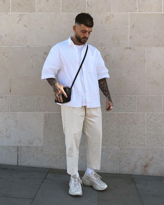 a neutral summer look with a white t-shirt, a white short-sleeved shirt, neutral cropped pants, neutral trainers and a black bag