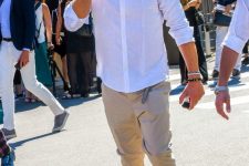 a simple everyday look with a white shirt, tan cuffed pants, grey trainers and stacked bracelets for spring or summer