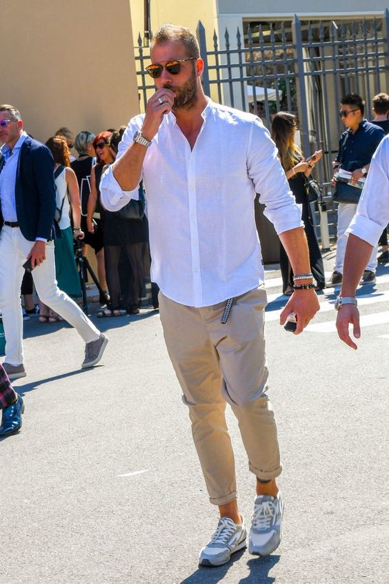 a simple everyday look with a white shirt, tan cuffed pants, grey trainers and stacked bracelets for spring or summer