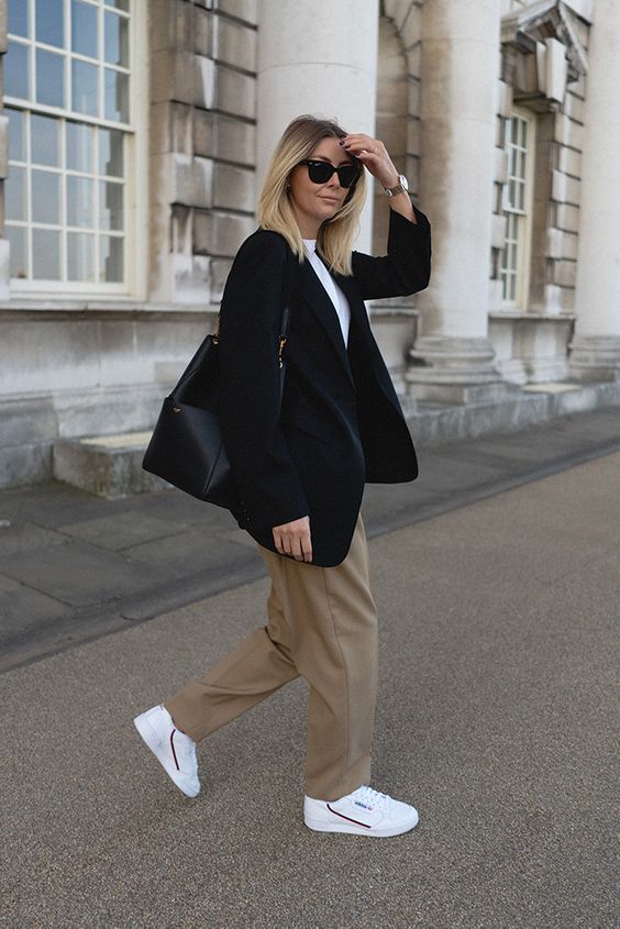 a smart casual look with a white shirt, taupe pants, white sneakers, an oversized black blazer and a bag, chic watch