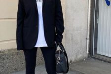 a sport chic monochromatic look with a white tee, black leggings and a black oversized blazer, white socks and trainers, a black bag