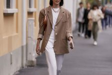 a stylish and elegant outfit with a white t-shirt, trousers, white strappy heels and a brown bag