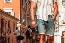 a summer look with a vertical stripe short-sleeved shirt, blue denim shorts, brown birkenstocks and a straw hat