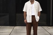 a summer look with a white tank top and a white linen shirt over it, brown trousers and white platform sneakers