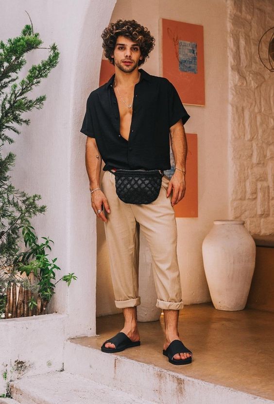a summer or vacation look with a black short sleeved shirt, tan cuffed pants, black slippers and a black waist bag is easy and cool