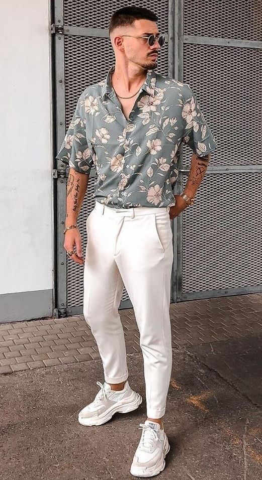 a summer outfit with a grey floral print short-sleeved shirt, white pants, white trainers and a necklace is easy and comfy
