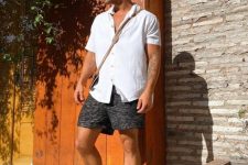a summer outfit with a white linen shirt, grey shorts, grey birkenstocks and a black bag