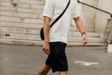 a summer sport chic look with a white short sleeved button down, black Bermuda shorts, black socks, colorful trainers and a black bag