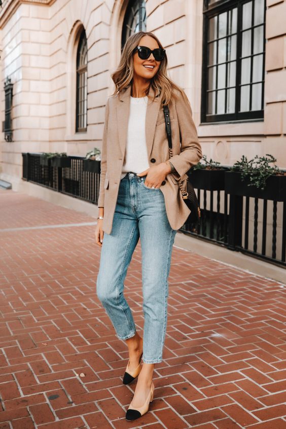 a timeless spring work outfit with a white t-shirt, a beige blazer, blue cropped jeans, two-tone shoes and a black bag