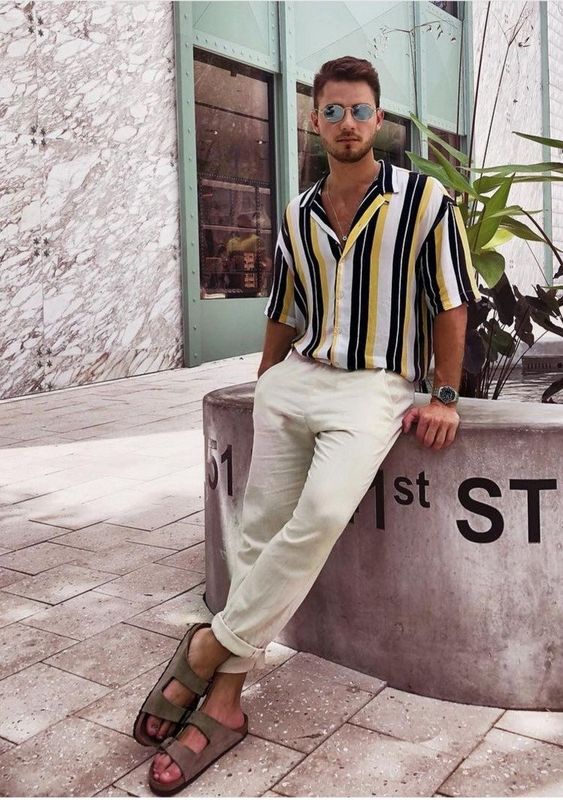 a vacation look with a vertical stripe short-sleeved shirt, neutral linen pants, grey birkenstocks is easy and comfortable