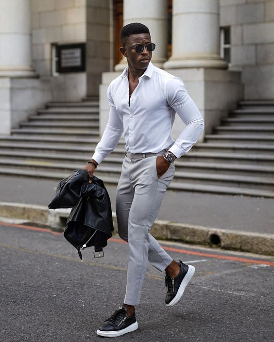 a white button down, grey cropped trousers, black platform sneakers, a black leather jacket for a chic smart casual look