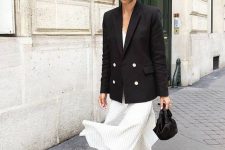 a white striped midi dress, a black blazer with white buttons, a black bag and sandals for a summer work look
