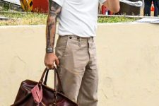 a white t-shirt, tan pants, blue sneakers, a burgundy bag compose a simple and comfortable everyday look in summer