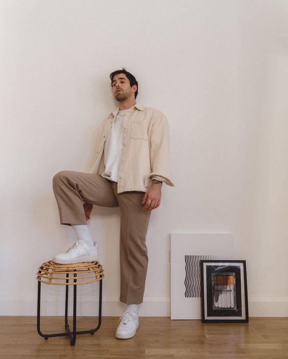 a white tee, a creamy jacket with pockets, taupe trousers, white socks and sneakers for a stylish monochromatic look