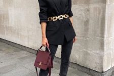 an edgy total black look with a t-shirt, cropped jeans, chunky boots, a blazer, a statement gold chain belt and a purple bag