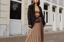 an elegant look with a tan top, a tan checked pleated midi, black boots, an oversized black blazer and a waist bag