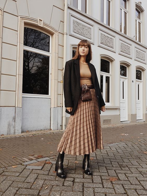an elegant look with a tan top, a tan checked pleated midi, black boots, an oversized black blazer and a waist bag