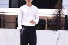 an elegant look with a touch of vintage, with a white mao shirt, thin striped pants, black loafers and a straw hat