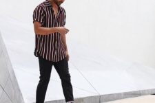 an oversized burgundy and white striped shirt, black thin striped pants, black high top sneakers