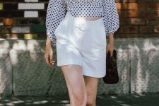02 a black and white crop top with long sleeves, white high waisted shorts, white shorts, a straw hat and a black bag