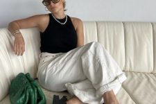 03 a black and white outfit with a black halter neckline top, white jeans, black birkenstocks and a green clutch plus a necklace