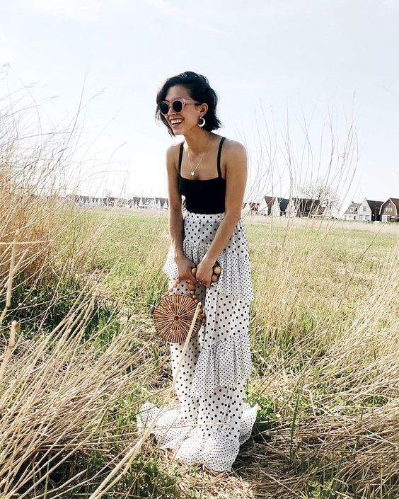 a catchy outfit for a special occasion - a black spaghetti strap top and a mixed print polka dot maxi skirt wiht a train, a wooden bag