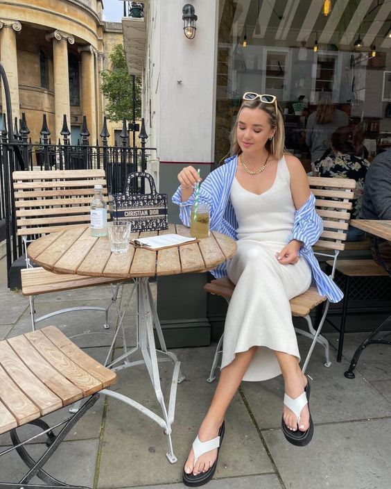 a creamy midi dress, a blue striped oversized shirt, white flipflops are perfect for a relaxed summer brunch