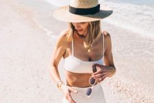 07 a minimalist white swimsuit with a spaghetti strap top and a high waisted bottom plus a straw hat