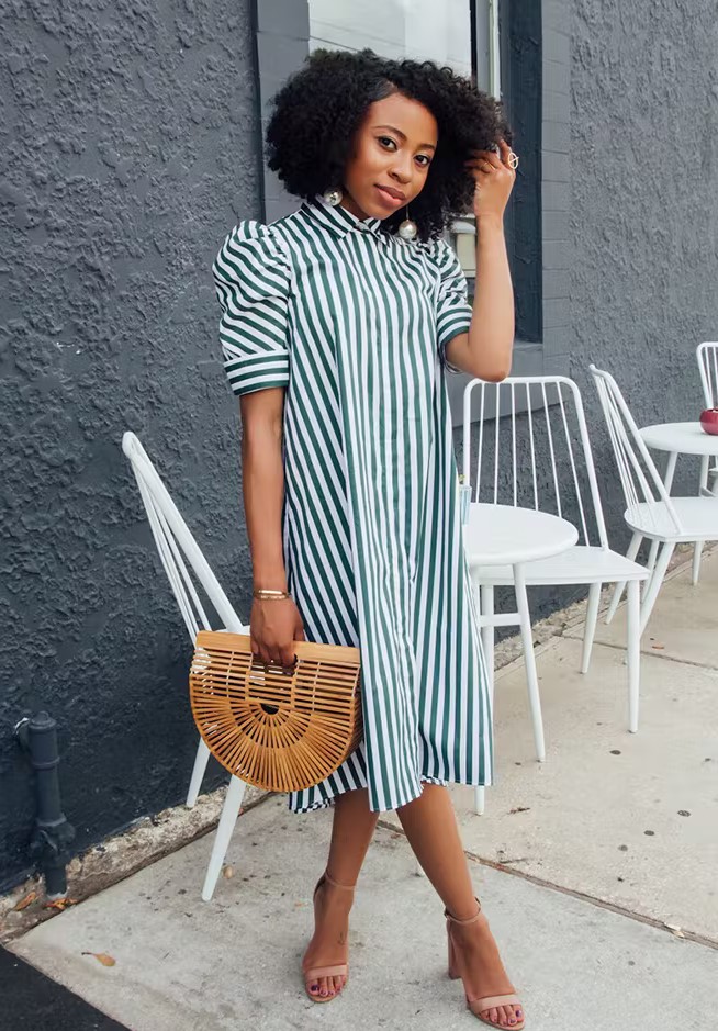 a vertical stripe green and white midi shirtdress with short sleeves, beige shoes and a wooden bag, statement earrings
