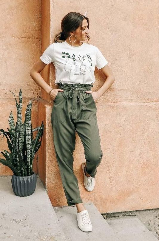 a casual summer look with a printed white t-shirt, green high waised pants, neutral sneakers is a lovely idea to try