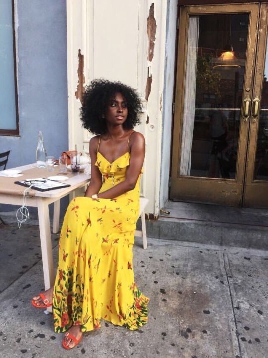 a yellow floral pint maxi dress with spaghetti straps and ruffles, orange shoes and a statement bracelet for a summer brunch
