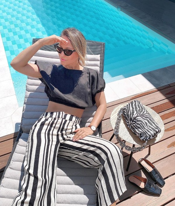a black and white brunch look with a black crop top, vertical strip pants, black mules and a zebra print bag